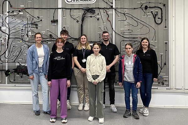 Teilnehmerinnen und Betreuer des Girls Day Abensberg vor einem Bordnetz.